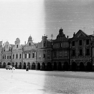 Historic European town square with arched buildings.