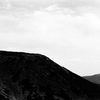Misty volcanic landscape with rugged terrain.