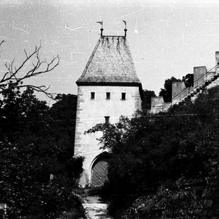 Medieval castle gatehouse with steep stone ramparts.