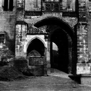 Gothic-style arched entrance with weathered stone facade.