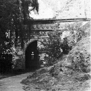 Stone archway entrance with rustic stonework and greenery.