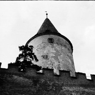 Medieval stone tower with conical roof.