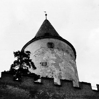 Medieval stone tower with conical roof.