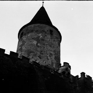 Medieval stone tower with conical roof.