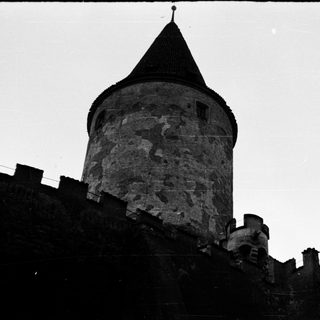 Medieval stone tower with conical roof.