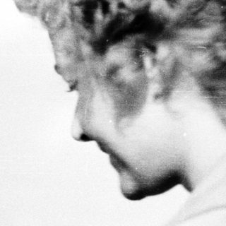 Blurred black-and-white portrait of a person outdoors.