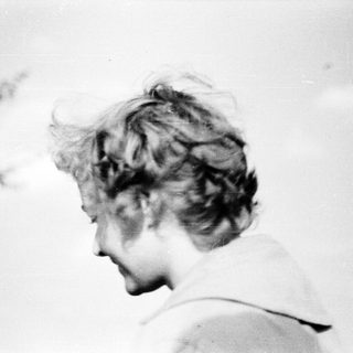 Blurred black-and-white portrait of a person outdoors.