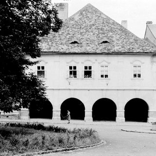 Historic building with arched ground floor and classical architecture.