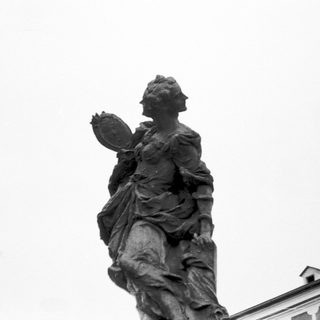Statue of woman holding palm frond.