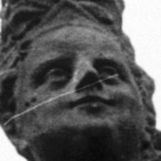 Statue of woman riding horse, raising arm.