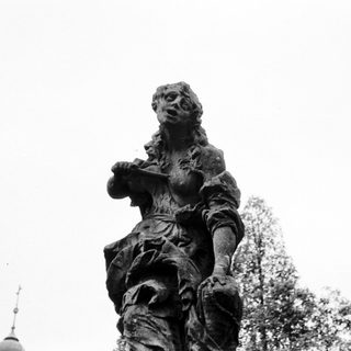 Statue of a robed figure holding a basket.