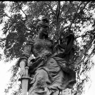 Statue of draped warrior holding sword.