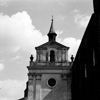 Classic church tower with steeple against cloudy sky.
