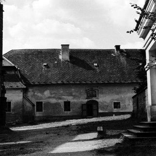 Abandoned stone building with aged roof and courtyard.