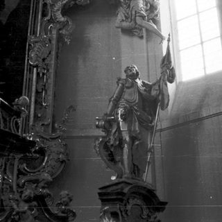 Baroque-style statue of saint in church interior.