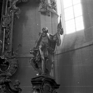 Baroque-style statue of saint in church interior.
