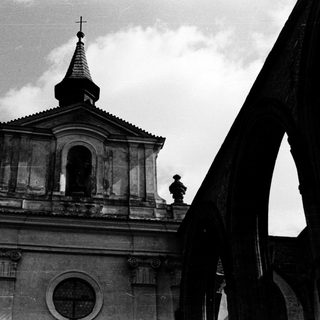 Neoclassical church with bell tower and cross.