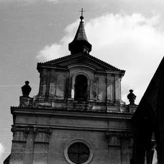 Neoclassical church with bell tower and cross.