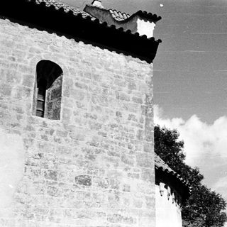 Stone building facade with arched window.