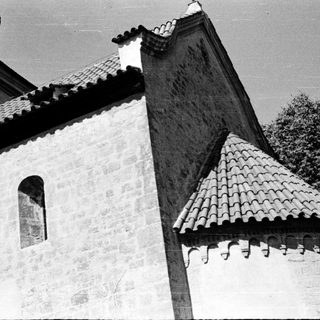Traditional stone building with tiled roof peaks.