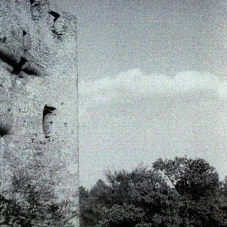 Ancient stone ruins with cloudy sky.