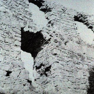 Stone wall with large vertical crack.