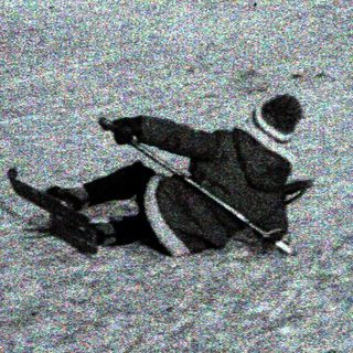 Person sledding on snow-covered ground near parked cars.