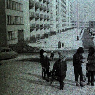 Children playing and walking in snowy urban residential area.