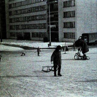 Children playing in snowy urban area.