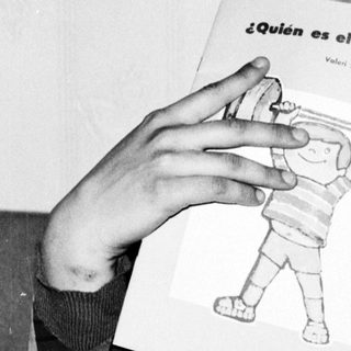 Person holds sign asking "Who is the strongest?" with a drawing of a robot.