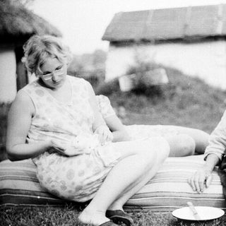 Two women sitting outdoors, engaged in conversation.