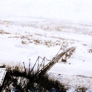Flooded landscape with partially submerged bridge.