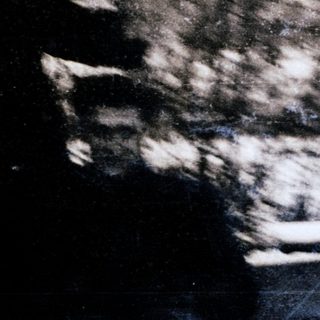 Blurred person riding motorcycle on road.