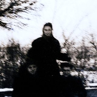 Blurred person riding motorcycle on road.