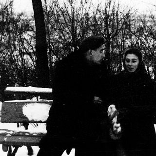 Two people sitting together outdoors in winter.