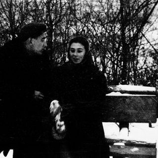 Two people sitting together outdoors in winter.