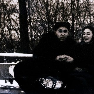 Two people sitting together outdoors in winter.