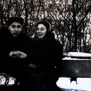 Two people sitting together outdoors in winter.