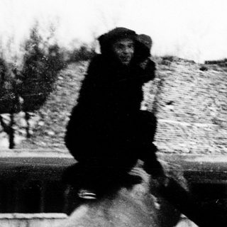 Child riding a donkey with adult guiding nearby.