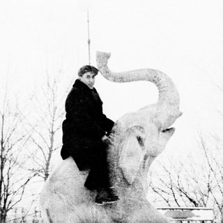 A person riding atop an elephant statue.