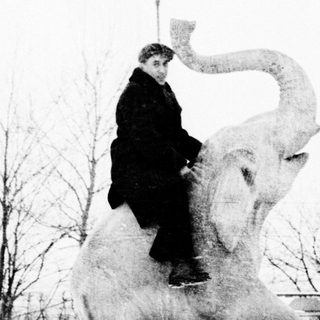A person riding atop an elephant statue.