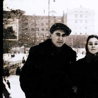 Three individuals posing outdoors in winter clothing.