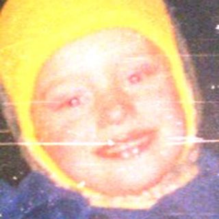 Child wearing winter gear inside ice cave.