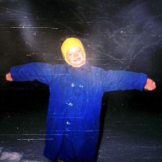 Child wearing winter gear inside ice cave.