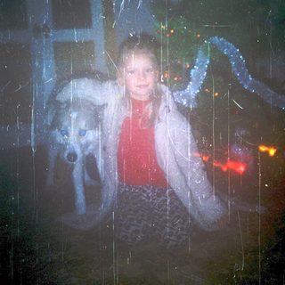 A woman and dog seen through rain-soaked window.