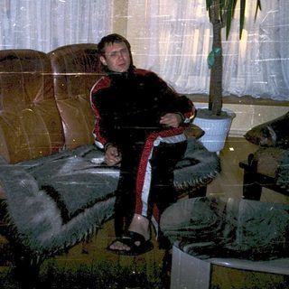Person sitting on a couch indoors during snowfall.