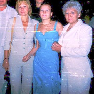 Five adults posing together at night event.