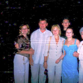 Five adults posing together at night event.