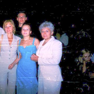 Five adults posing together at night event.