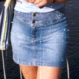 Woman smiling by waterfront during light rain.